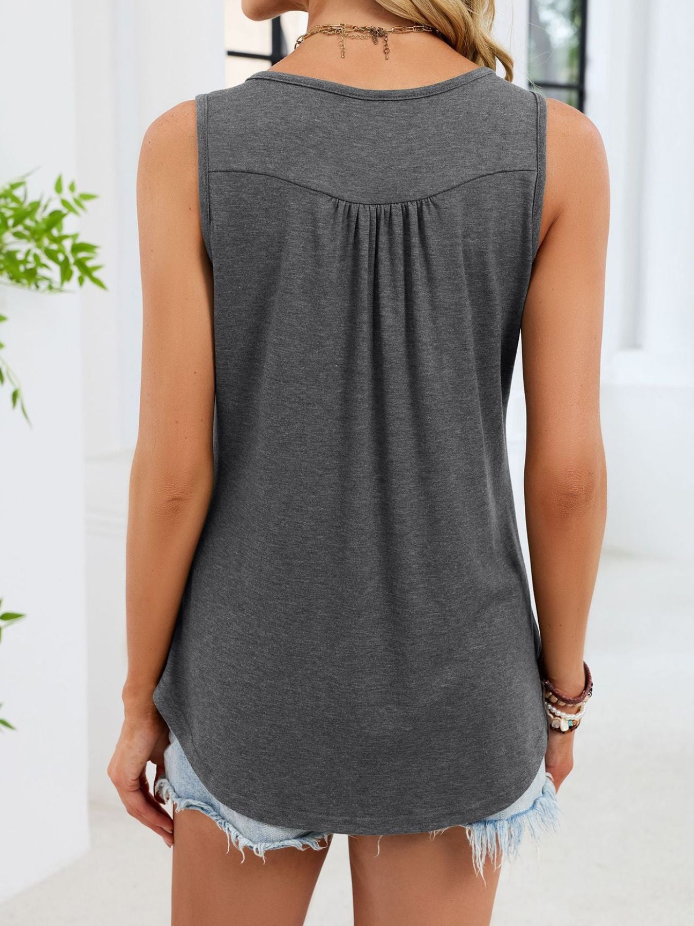 Gray ruched tank top with button detail and curved hem.