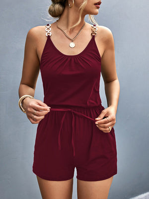 Burgundy chain-strap drawstring romper with ruched neckline and gold-tone hardware.