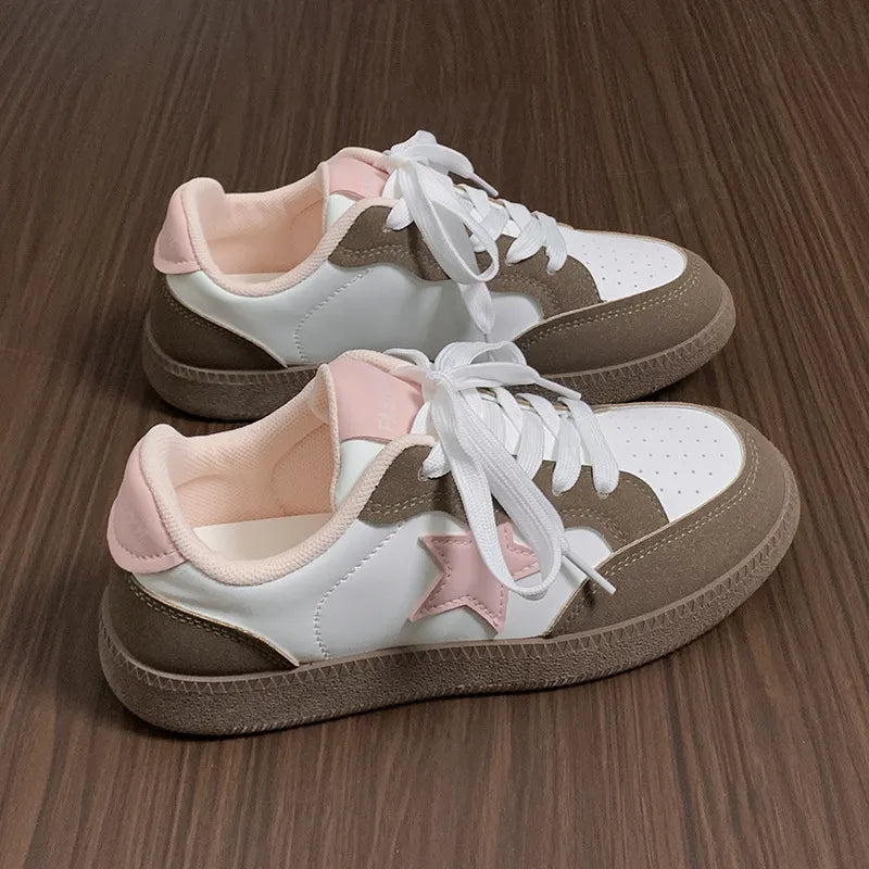 Retro court sneakers in white with blush pink star appliqué and brown accents.