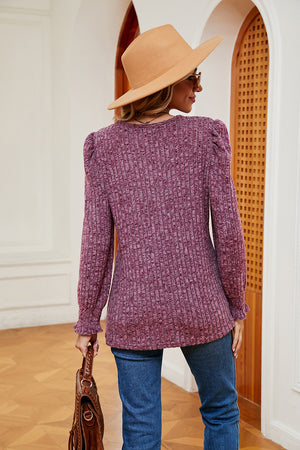 Textured knit blouse in fuchsia with square neckline, puffed shoulders, and ruffled cuffs.