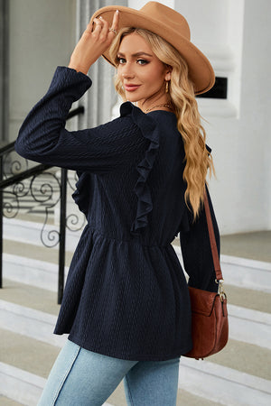 Dark blue textured peplum blouse with ruffle detail and long sleeves.