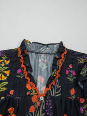 Black floral print maternity shirt with V-neck, frill detail, and orange trim.