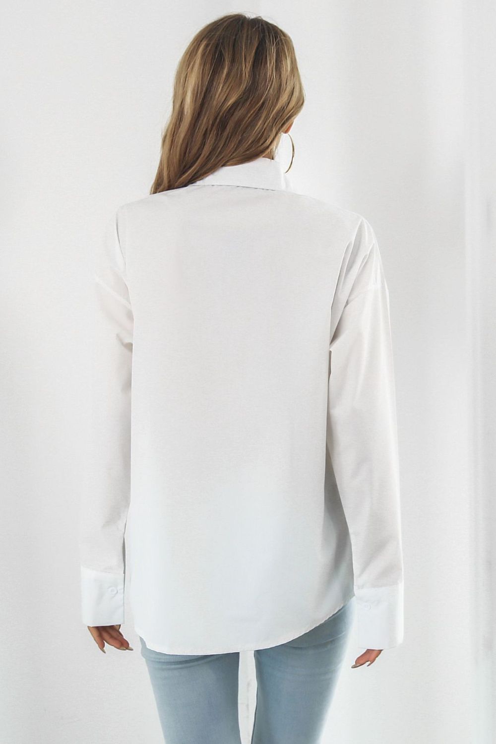 Oversized white cotton poplin shirt with buttoned cuffs and a classic collar.