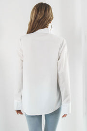 Oversized white cotton poplin shirt with buttoned cuffs and a classic collar.