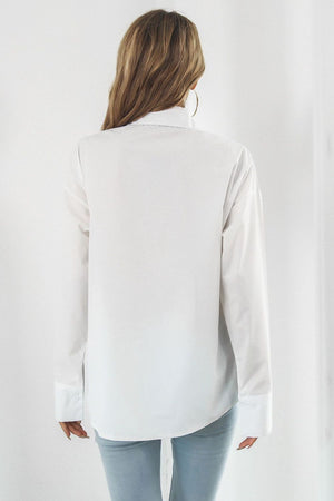 Oversized white cotton poplin shirt with buttoned cuffs and a classic collar.