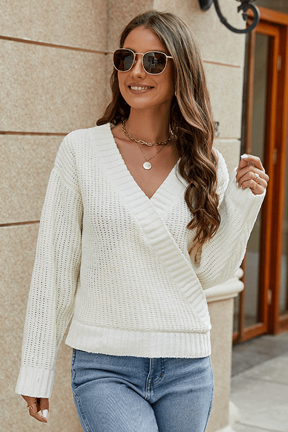 Ivory wrap knit v-neck pullover sweater with long sleeves and ribbed trim.