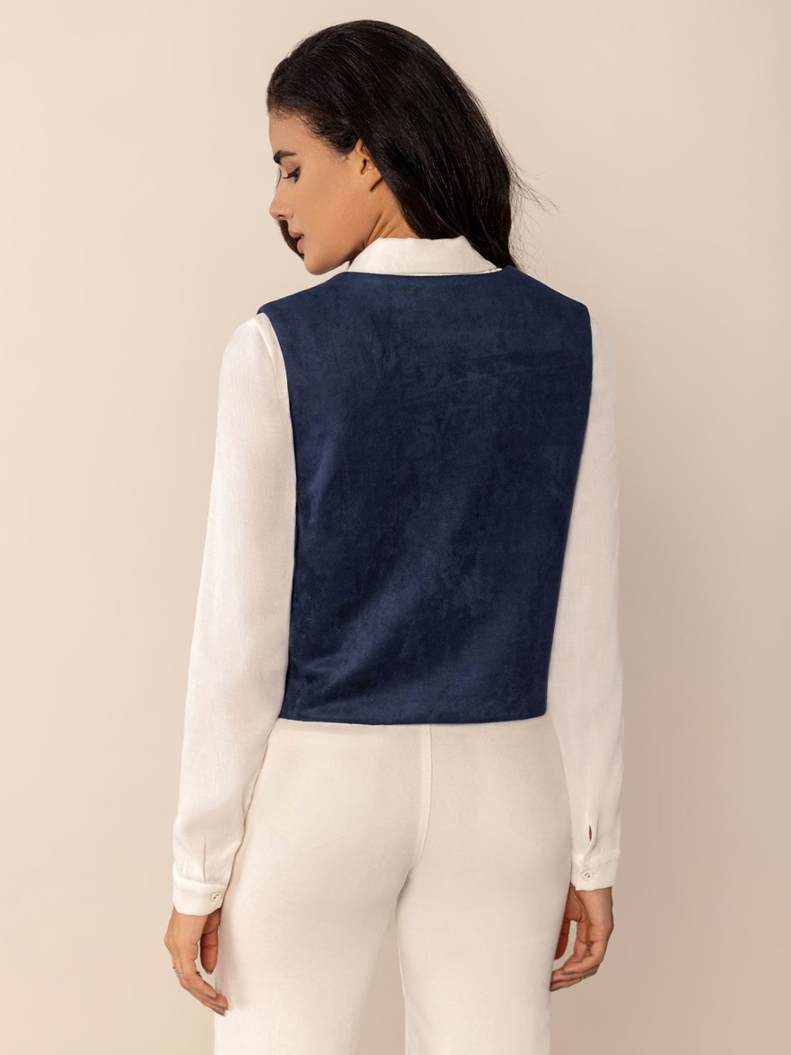 Dark blue suede-effect vest with stitch trim detail worn over a white shirt.