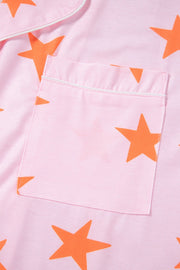Blush pink pajama top with orange stars and white piping detail on pocket.