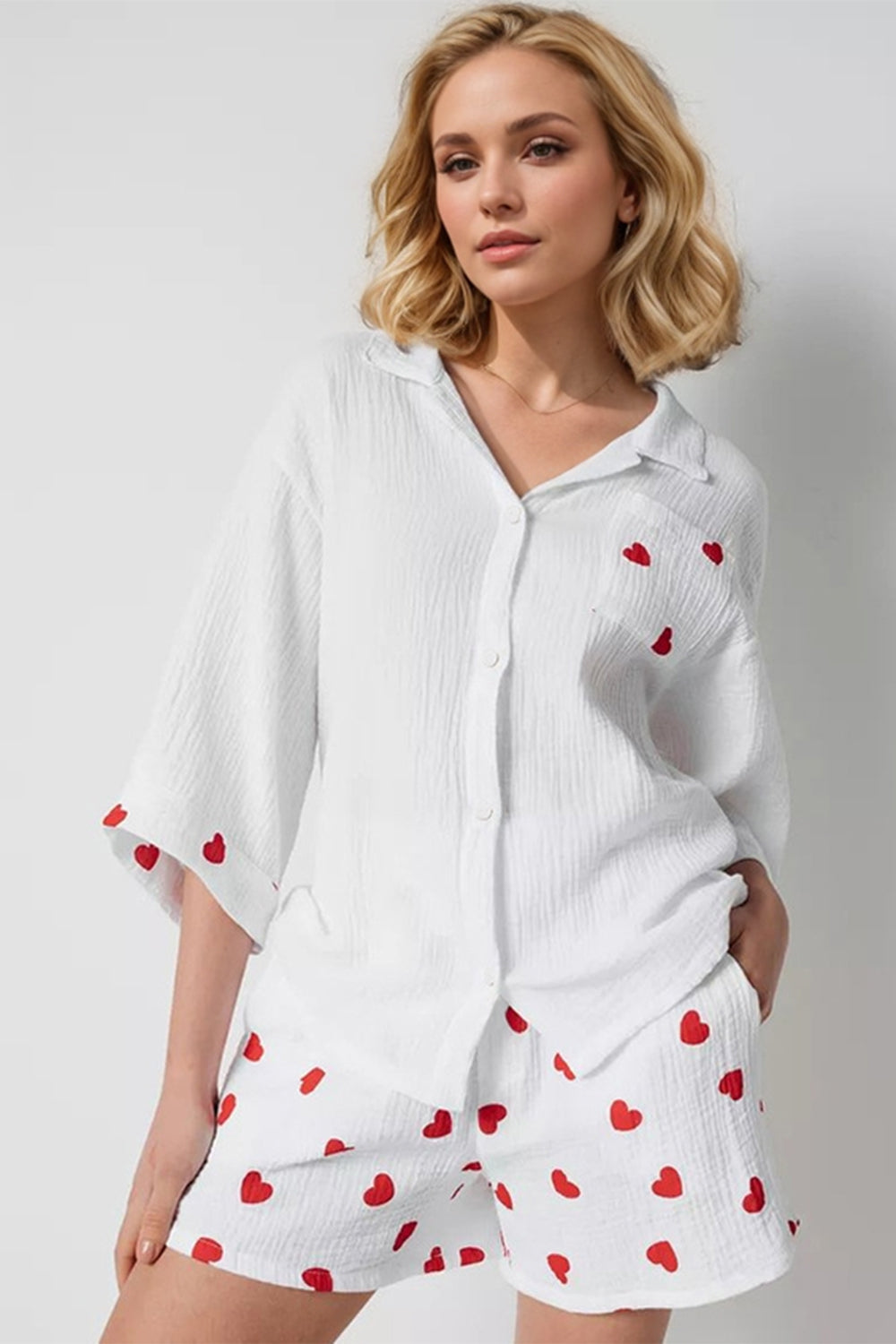 White gauze pajama set with red heart print, collared button-up shirt and shorts.