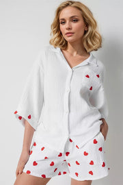 White gauze pajama set with red heart print, collared button-up shirt and shorts.