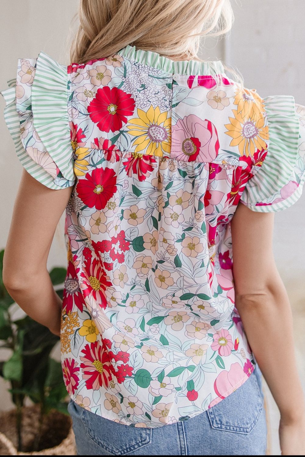 Floral ruffle sleeve blouse with a mixed floral print and green striped accents.