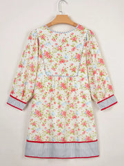 Floral cotton dress with puff sleeves, contrast trim, and striped hem.