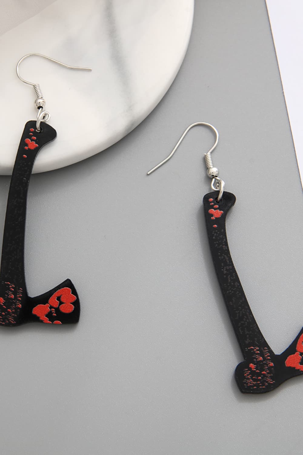 Black drop earrings shaped like gory blades with red accents.