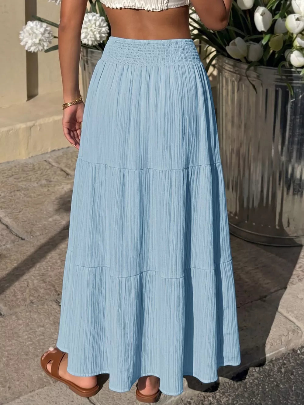 Blue smocked tiered maxi skirt with flowing elegance and textured fabric.