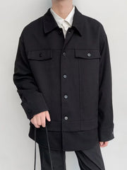 Black oversized button-down jacket with two chest pockets and button cuffs.