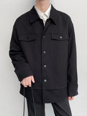 Black oversized button-down jacket with two chest pockets and button cuffs.