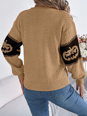 Camel knit sweater with jack-o'-lantern intarsia on sleeves.