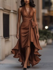 Brown satin high-low ruffled maxi dress with cinched waist and bow detail.