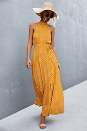 Yellow polka dot halter neck maxi dress with tiered skirt and tie waist.