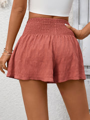 Smocked waist drawstring shorts in Red Bean Paste with textured fabric.