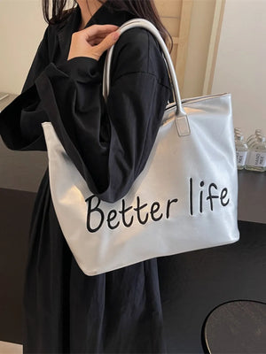 Silver metallic tote bag with black "Better life" graphic and top handles.
