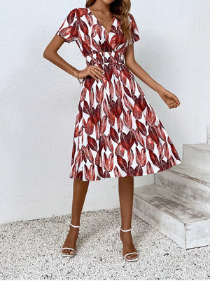 Red leaf pattern midi dress with v-neck, short sleeves, and elastic waist.