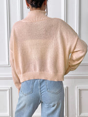 Blush pink ribbed turtleneck knit sweater with a cropped length and cuffed hem.