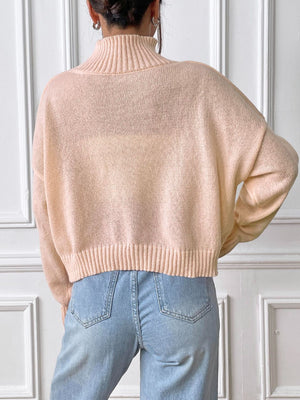 Blush pink ribbed turtleneck knit sweater with a cropped length and cuffed hem.