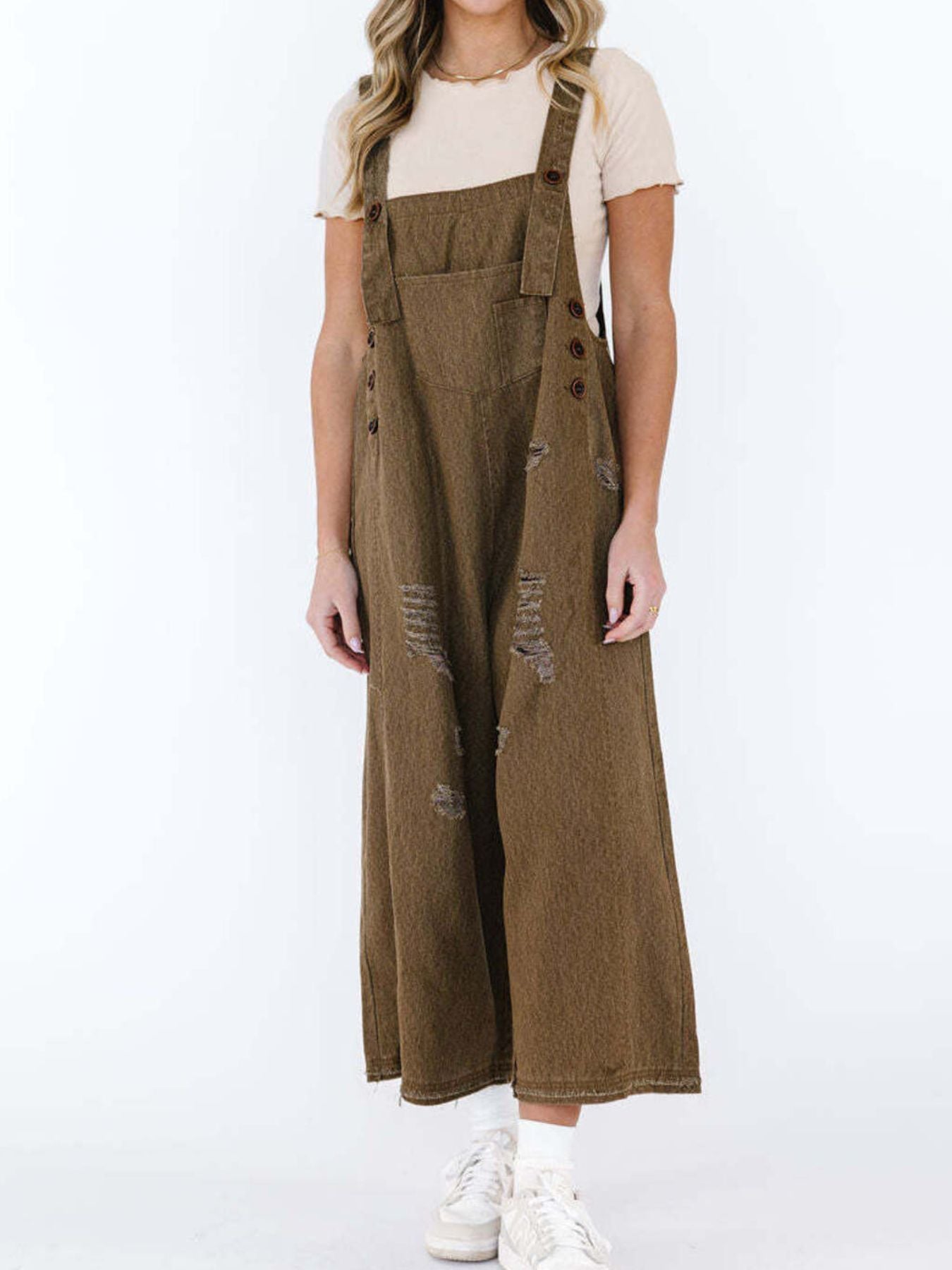 Brown ripped relaxed fit denim overalls with adjustable straps and button closures.