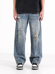 Men's distressed wide-leg jeans in washed blue denim with ripped details.