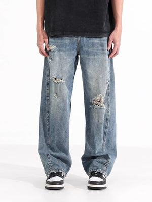 Men's distressed wide-leg jeans in washed blue denim with ripped details.