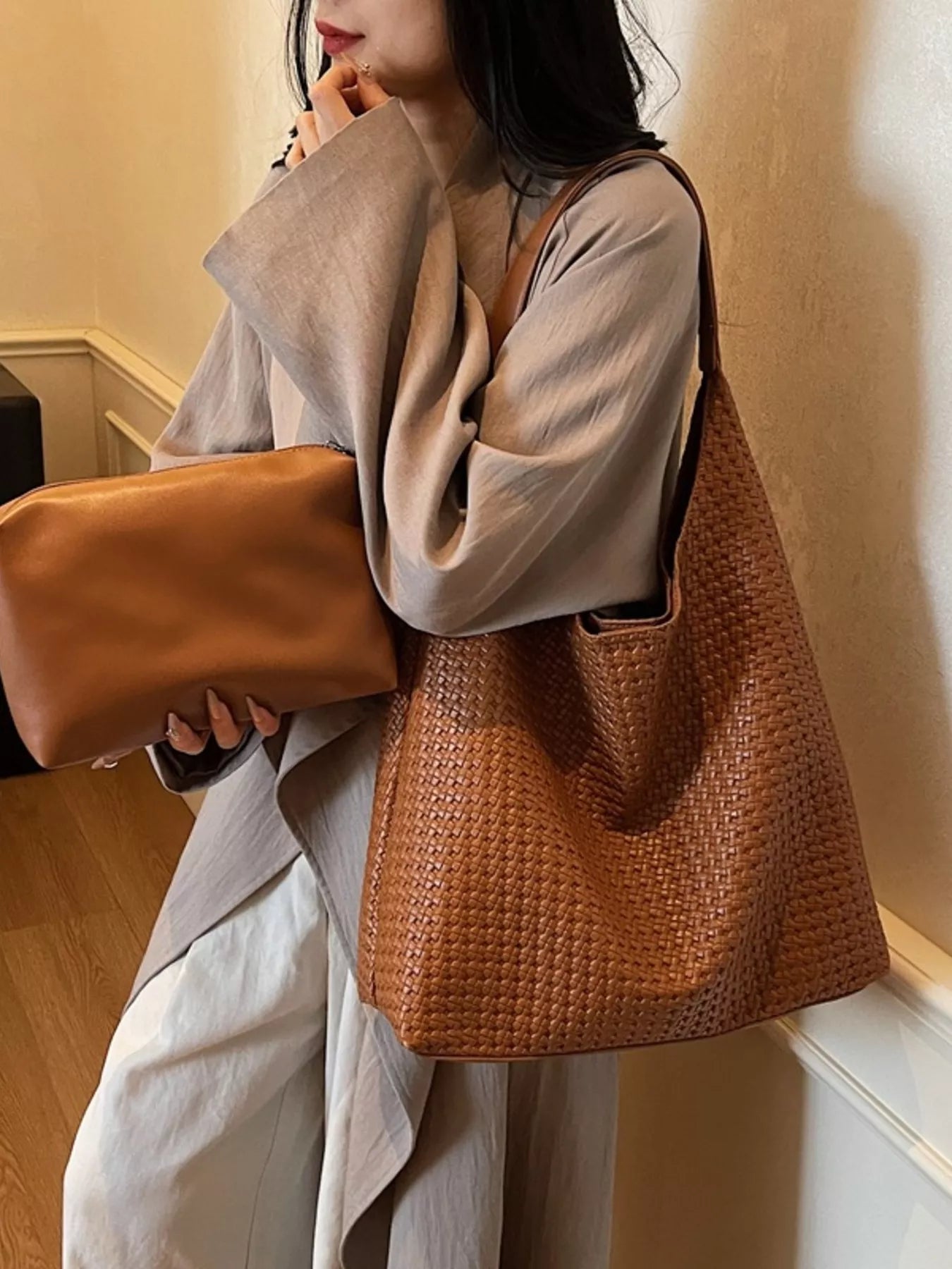 Brown woven straw tote bag with leather strap and matching clutch.