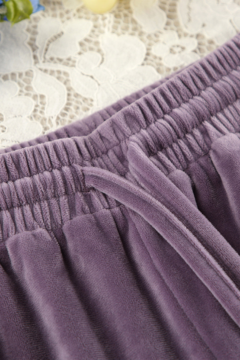 Mauve velvet lounge pants with drawstring and elastic waistband detail.