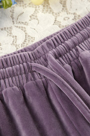 Mauve velvet lounge pants with drawstring and elastic waistband detail.