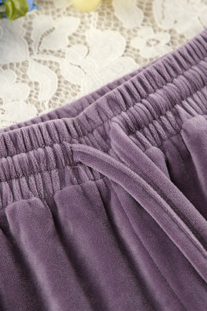 Mauve velvet lounge pants with drawstring and elastic waistband detail.
