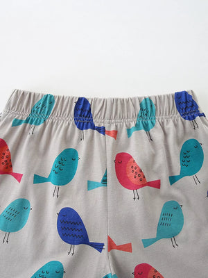 Gray cotton toddler shorts with a playful all-over bird graphic in blue, teal, and coral.