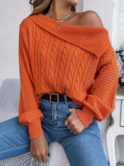 Orange off-shoulder cable knit pullover sweater with asymmetrical neckline and cuffed sleeves.