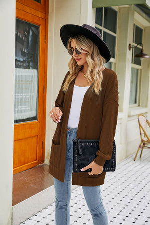 Chestnut cable-knit cardigan with pockets and a textured pattern.