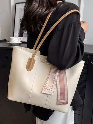 Elegant white pu leather tote bag with tan straps and decorative pink scarf.