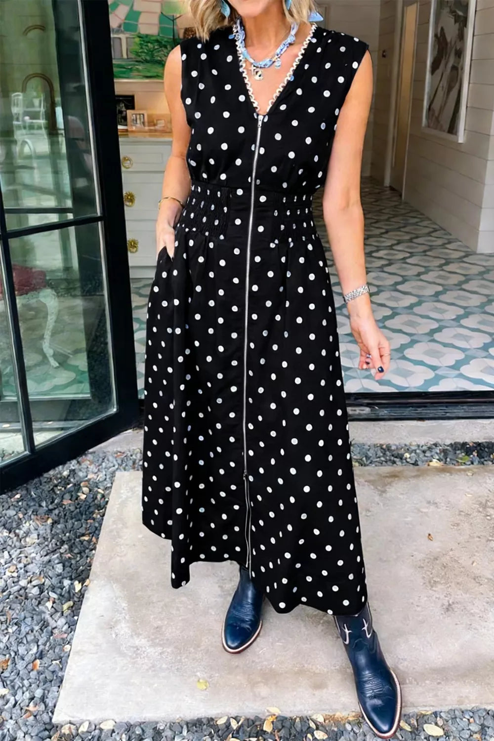 Black polka dot midi dress with zipper, smocked waist, and pockets