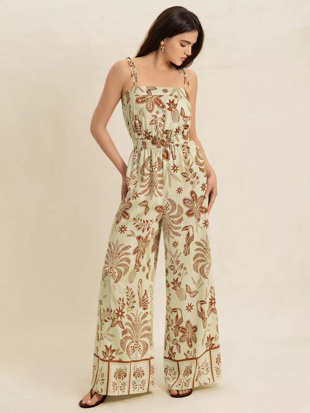 Tropical tie strap wide-leg romper in light green with brown floral and bird print.