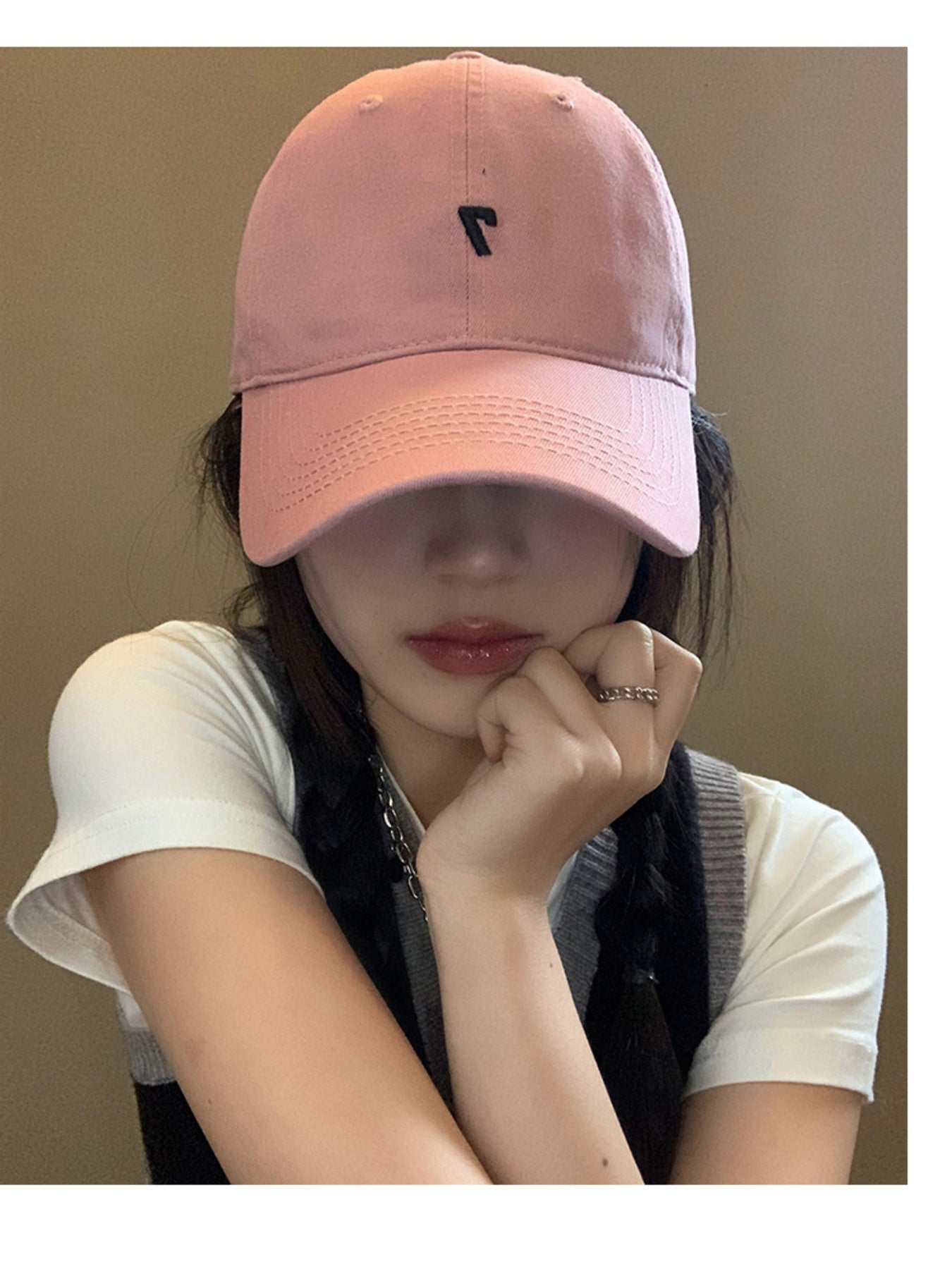 Pink cotton baseball cap with black embroidered detail and stitched brim.