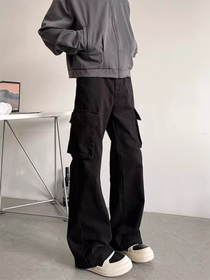 Black cargo pants with large side pockets, styled with a grey jacket and sneakers.