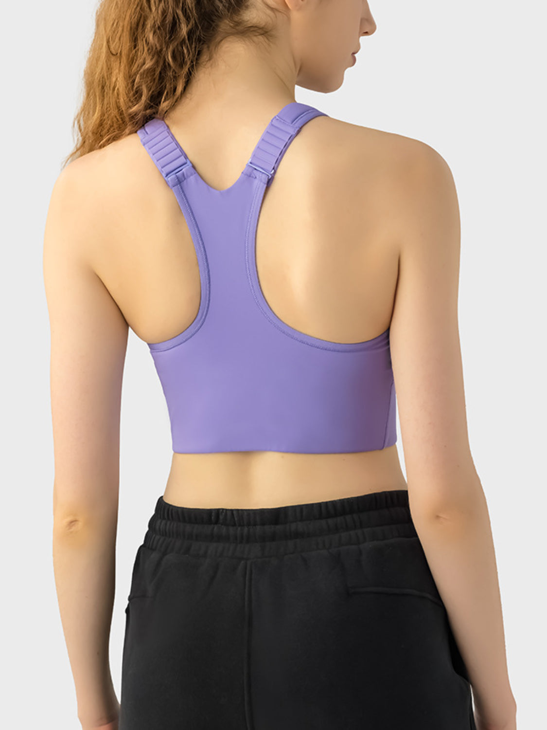 Purple zip-front racerback sports bra with adjustable straps.