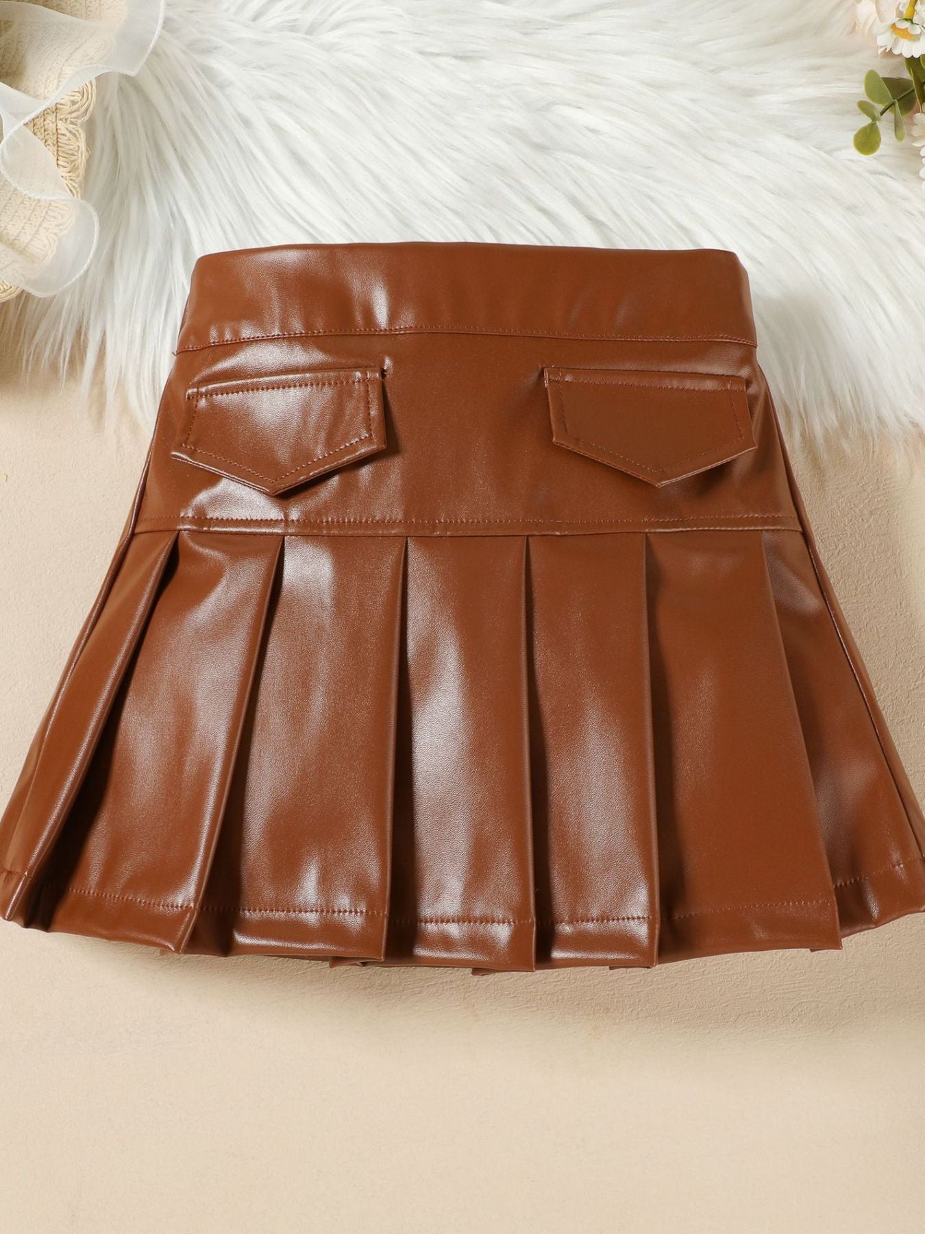 Toddler brown faux leather pleated skirt with two front pockets.