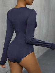 Long sleeve blue bodysuit with puff shoulder detail and lace trim.