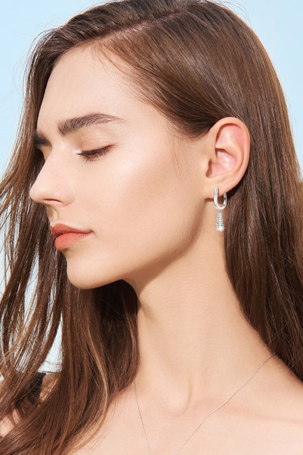 Silver cascading moissanite hoop earrings with a dangling charm.