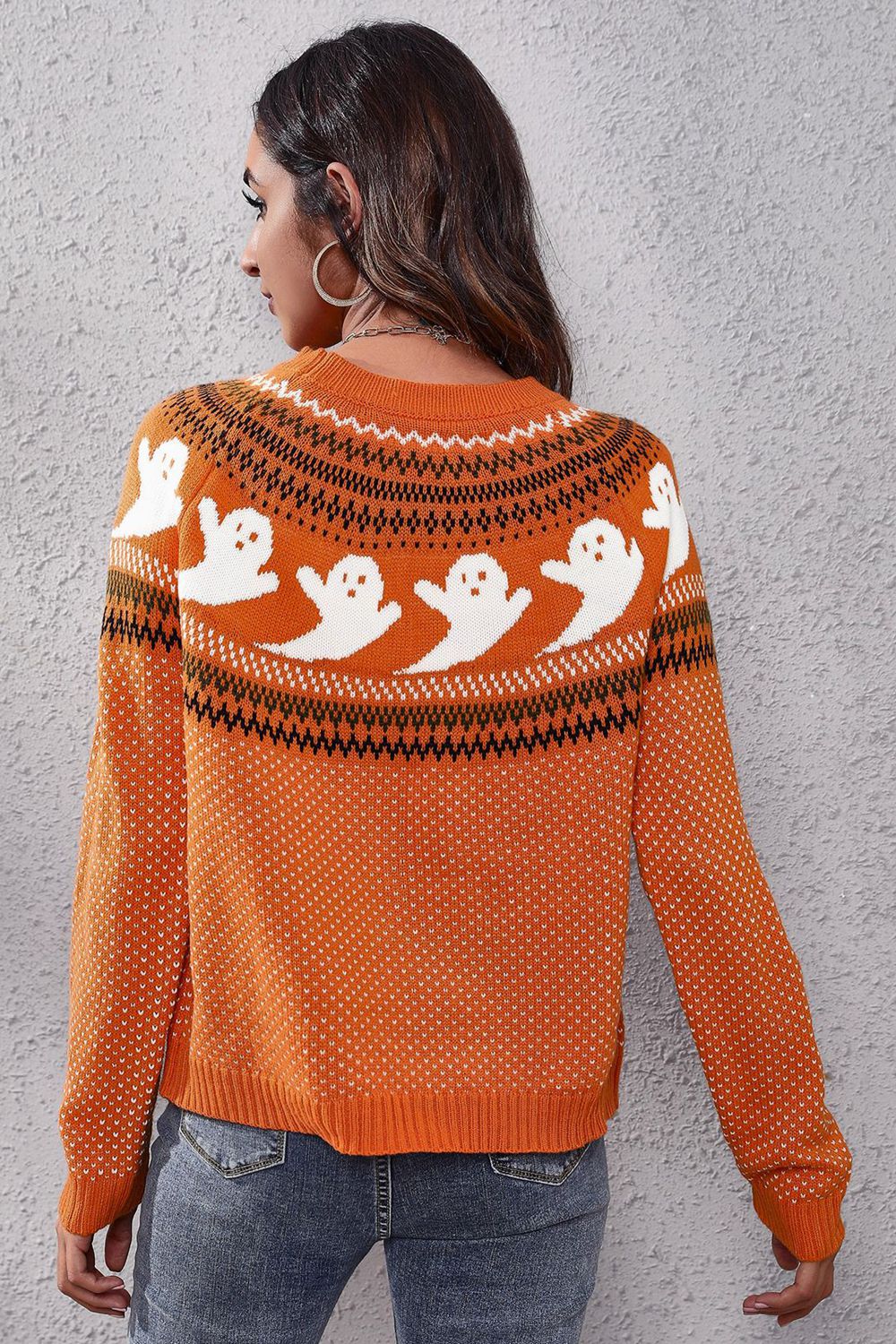 Orange crewneck sweater with white ghost pattern and fair isle detail