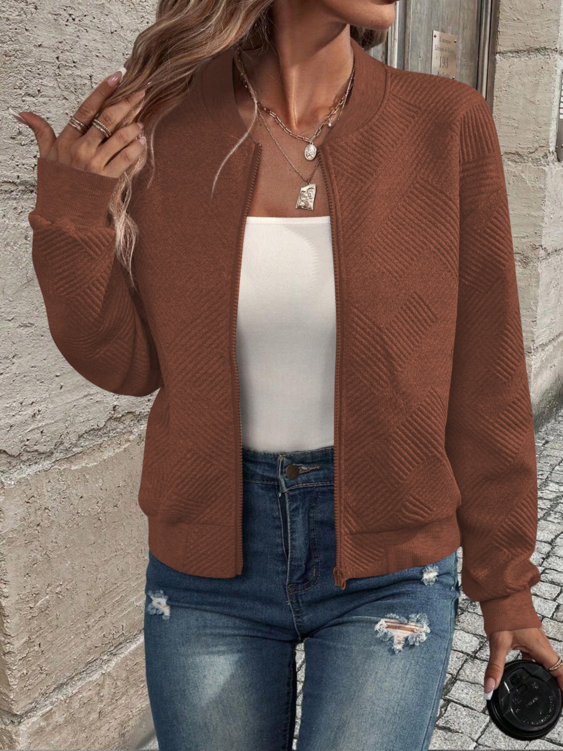Caramel geometric quilted bomber jacket with zipper and ribbed cuffs.