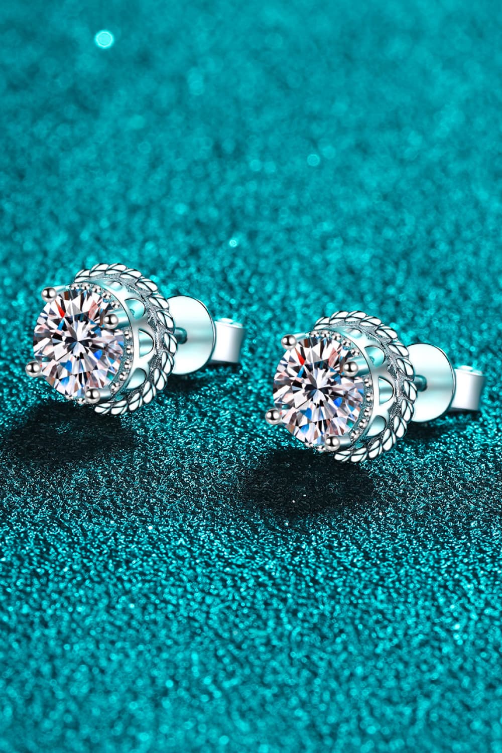 Sterling silver stud earrings with moissanite and rope-inspired framing.